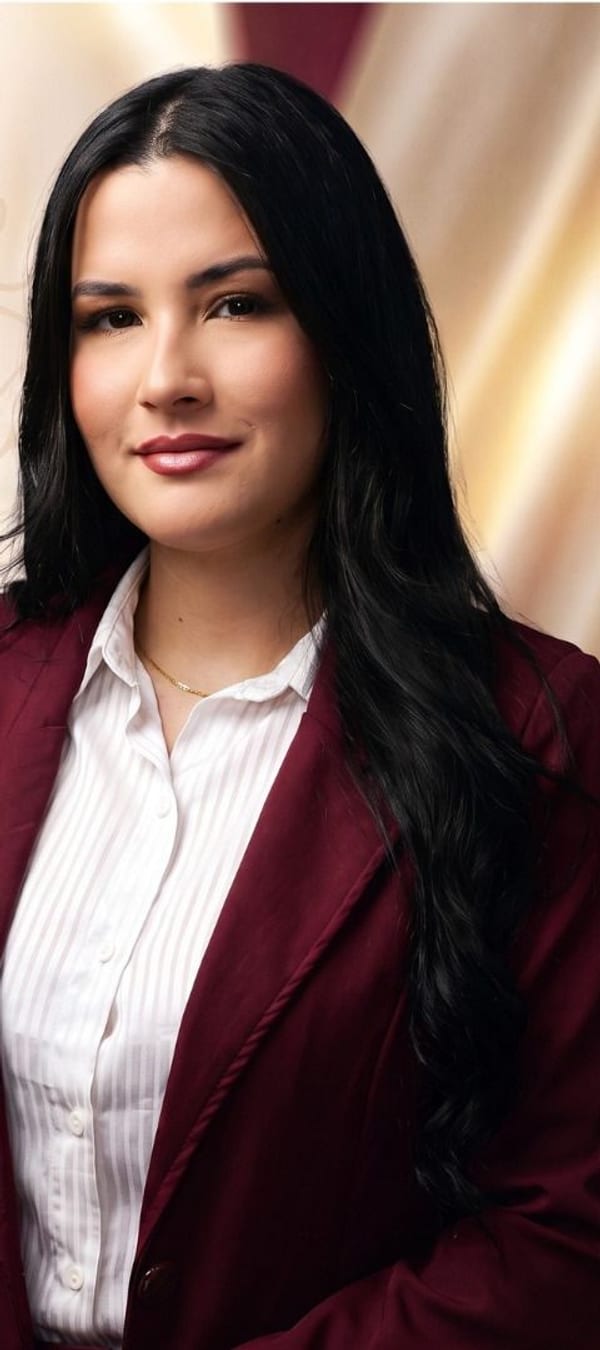 Bianca Camargo em traje formal bordô, transmitindo autoridade e credibilidade profissional